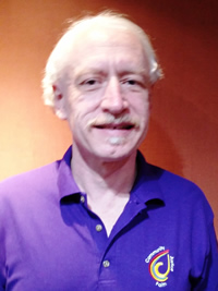 Bert wearing purple polo shirt with CWACM logo