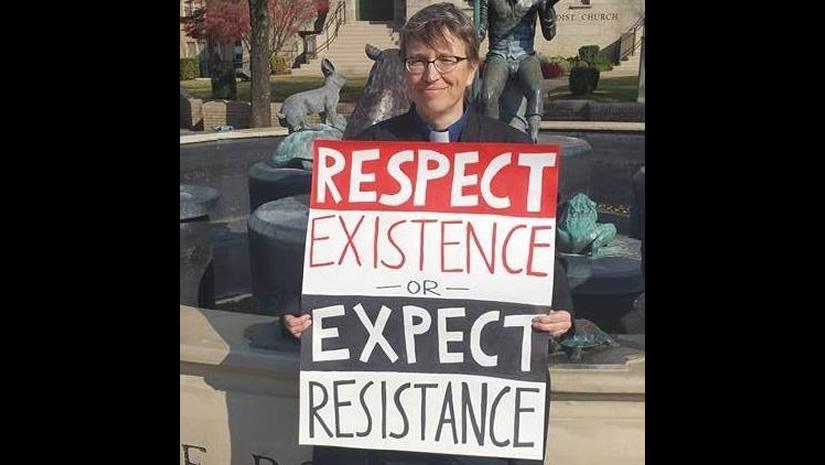 Jennifer Sanders holds sign that says "Respect Existence or Expect Resistance"