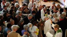Participants in the 2008 Extraordinary Ordination gather around the ordinand to lay hands